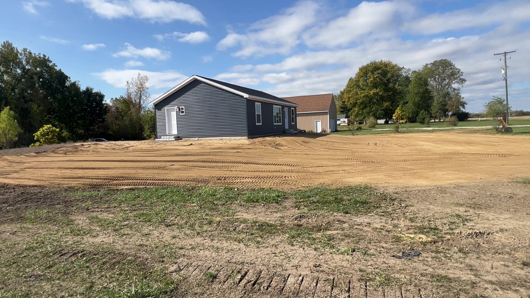 New build sandy loam grading for water to shed away from the home